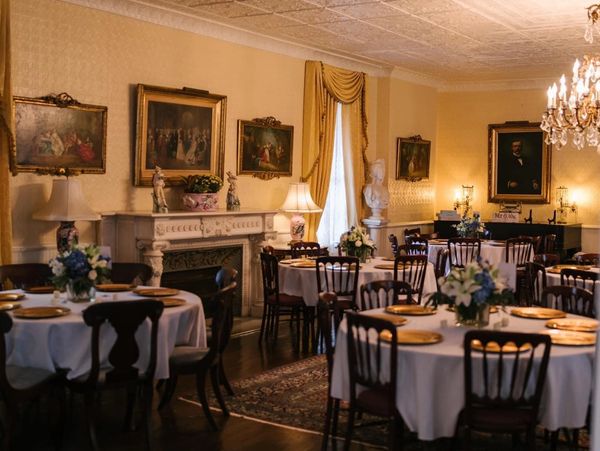 ballroom with table and chairs with antique photos