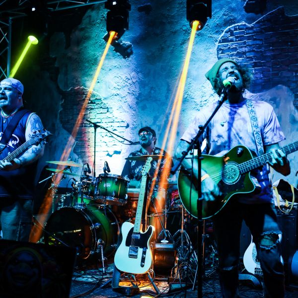Band performing live with dramatic lighting.