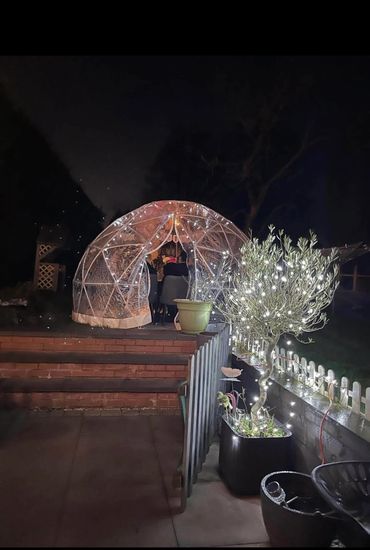 On outside view of igloo, lit up with fairy lights.