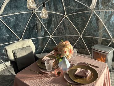 A pink themed cozy date night set up with mood lighting and fireplace.