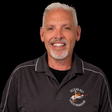 Smiling man in a black Pelican Bay Athletic Organization polo shirt.
