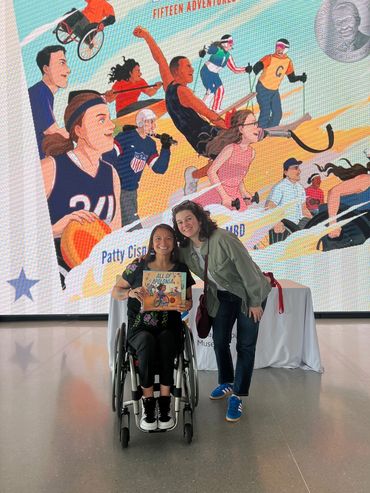 Patty and a lady posing for a picture with Tenacious on a giant screen in the background