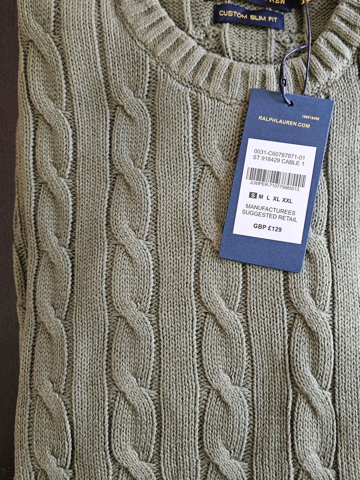 Folded olive-green cable knit Polo Ralph Lauren sweater with tags attached.