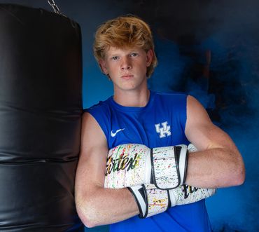 High School senior portrait in gym wearing boxing gloves