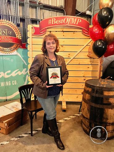 Tonya Brisson recieves a plaque from Mount Pleasant Magazine for Best Photographer