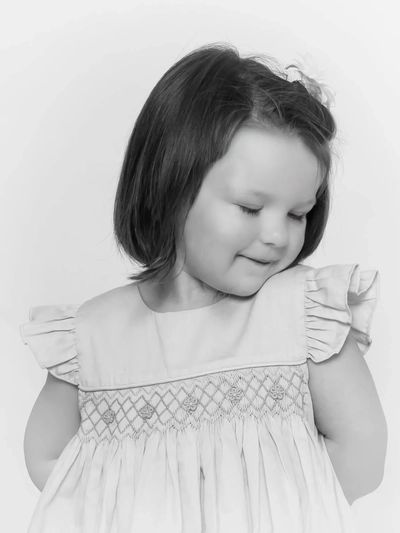 Timeless personality portrait of a toddler girl being shy, done in black and white