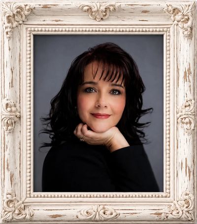A studio headshot of award winning photographer, Tonya Brisson. She wears a black top, has her chin