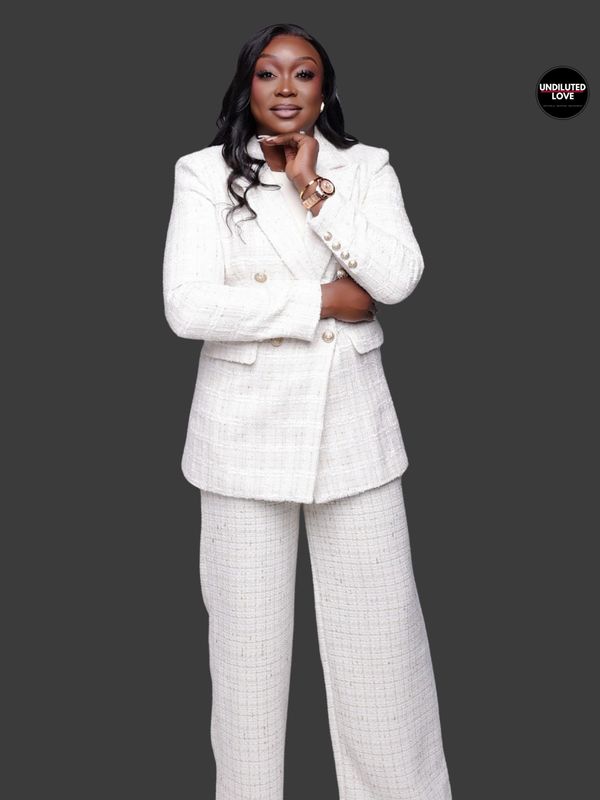 Confident woman in a stylish white suit against a gray background.