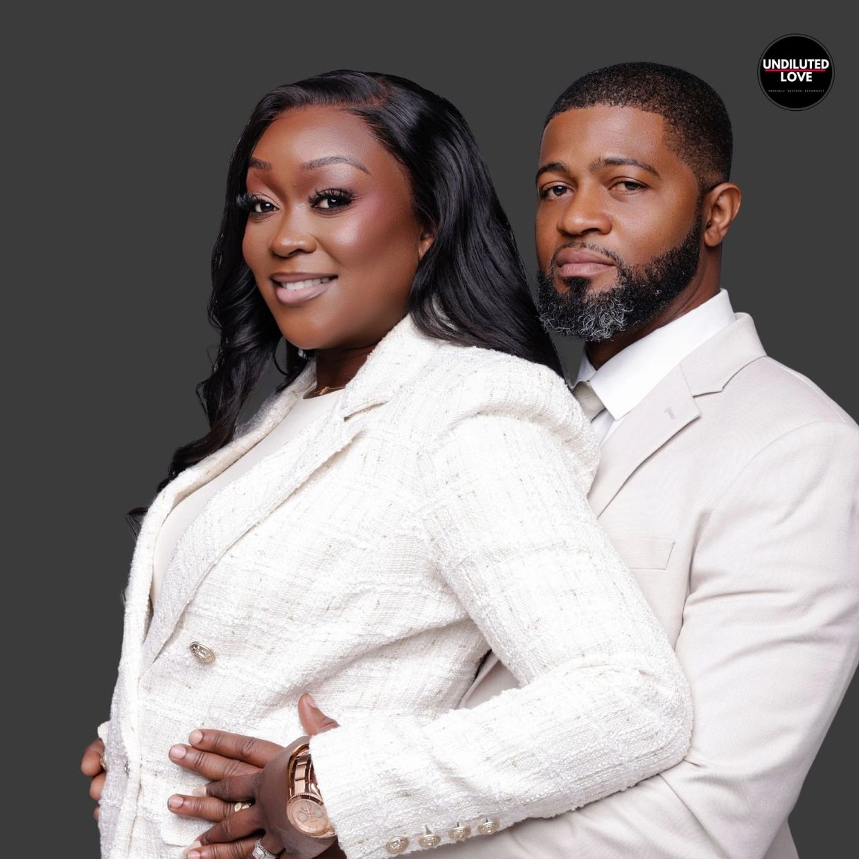 A smiling couple dressed in white against a dark background with 'Undiluted Love' logo.