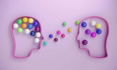 Two head outlines exchanging colorful balls.