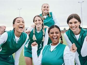 Group of female athletes smiling and celebrating.