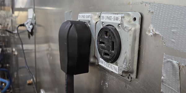 Close-up of electrical outlets on a metal wall.