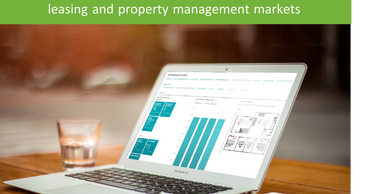 Laptop displaying leasing and property management data on a wooden table.