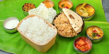 Traditional South Indian meal served on a banana leaf with rice, curry, and sides.