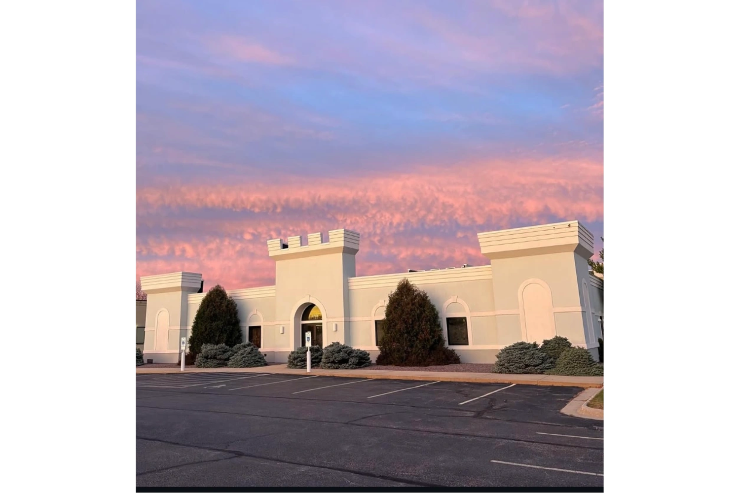 Building under a vibrant pink and blue sunset sky.