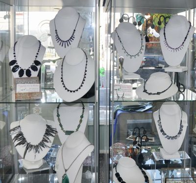 assortment of necklaces on display in glass case