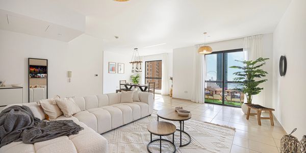 Bright, modern living room with cozy seating and balcony views.