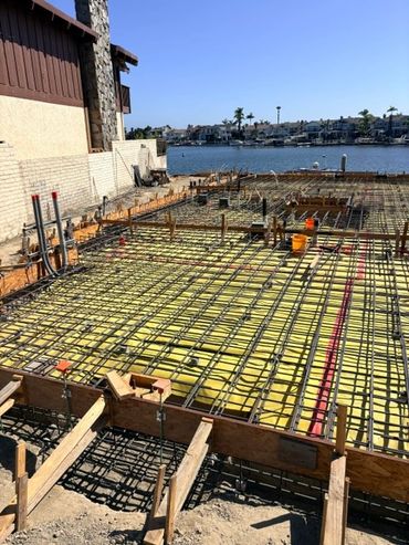 Steel reinforcement and wood forms prepared for a concrete slab pour beside a marina.
