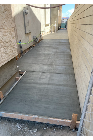 Concrete walkway running between two buildings.