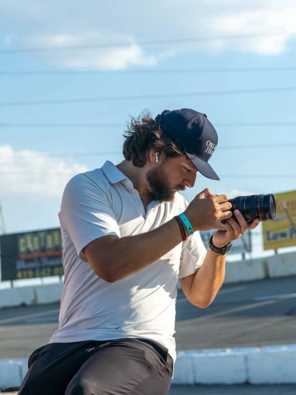 Man holding a camera and looking through the viewfinder.