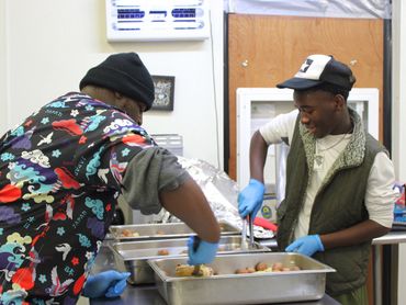 Two teens preparing lunch at Crosslines Community Outreach  for a Community Ambassador Project