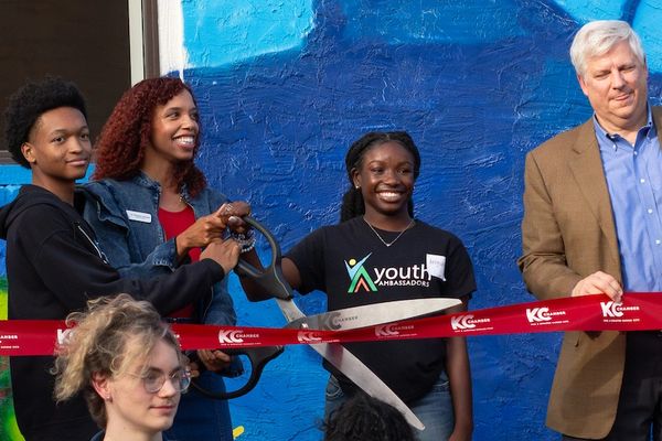 Dr. Monique Johnston, Peter Long, and two Ambassadors cutting the ribbon to our new building