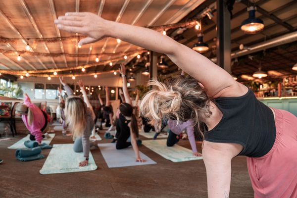 Group yoga class practicing side stretches in a cozy indoor studio.