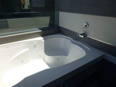 Empty white jacuzzi with water flowing in.