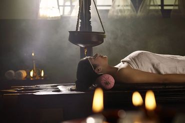 Ayurveda olie behandling med hængende svingende krukke