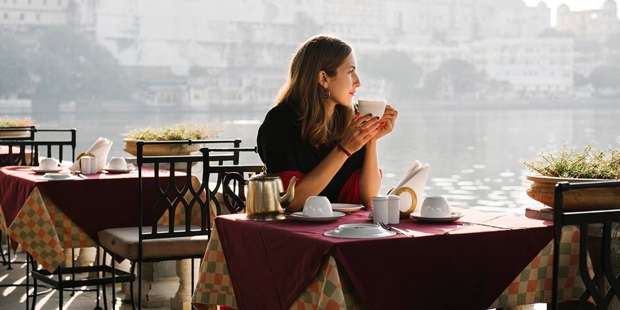 Kvinder drikker et kop kaffe og kigger over havet