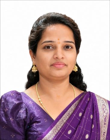 Woman in purple saree with gold jewelry.