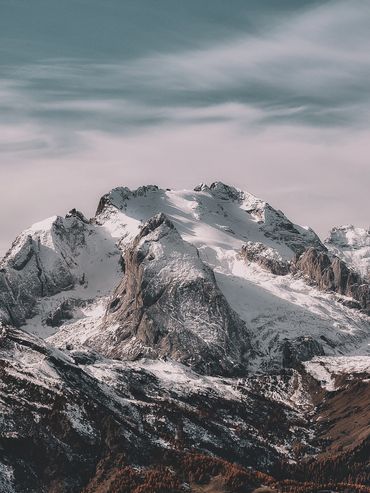 Snow-covered mountain peaks under a cloudy sky.