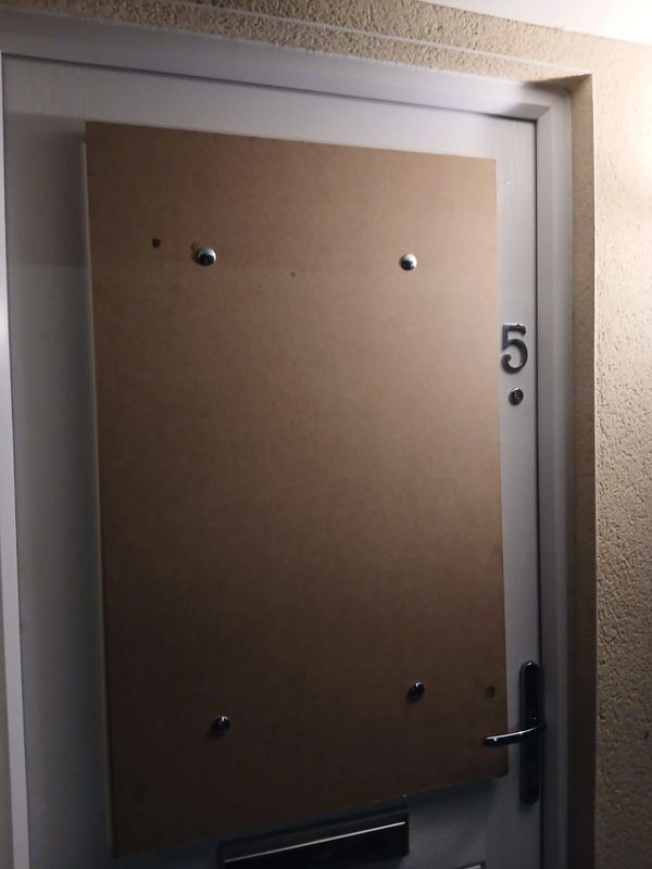Door number 5 boarded up with a wooden panel.