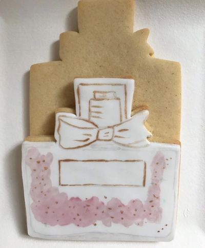 Fondant topped cookie painted with Edible Food Paint in front of undecorated cookie.