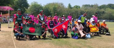 Group of wheelchair cricket players from Bangladesh, Nepal, and India gathered with flags.