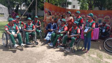 Group of wheelchair-bound athletes posing outdoors.