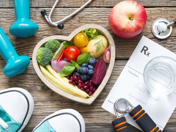 Healthy lifestyle essentials with fruits, veggies, and exercise gear.