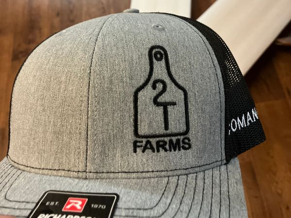 Gray and black trucker hat with 2T Farms logo embroidered on front.