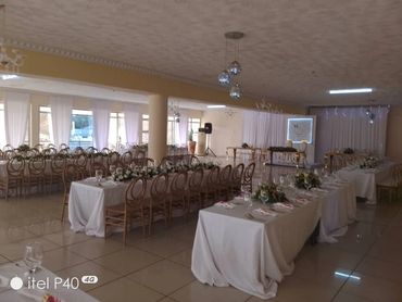 Elegant banquet hall set for a formal event with decorated tables and chairs.