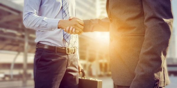 Dois homens dando as mãos em sinal de fechamento de um ótimo negócio