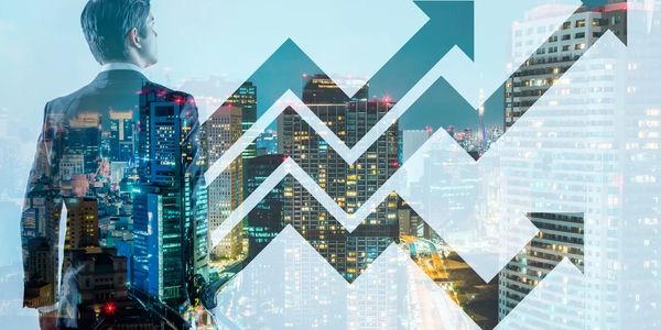 Executivo de Vendas olhando para arranha céus, com linhas de crescimento em vendas refletindo a tela