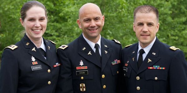 Three U.S. Army officers posing outdoors in uniform.