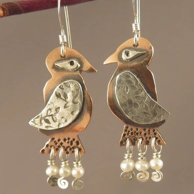 Miniature bird sculptures in copper and silver as unique wearable art earrings, by AlmaMia Jewelry.