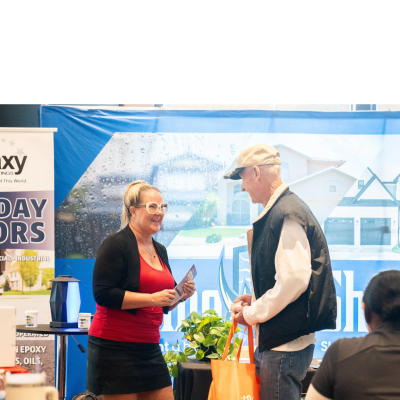 A woman and an older man engaging in conversation at an indoor event.