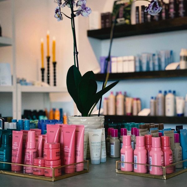 Various skincare products neatly arranged with a decorative orchid in the center.