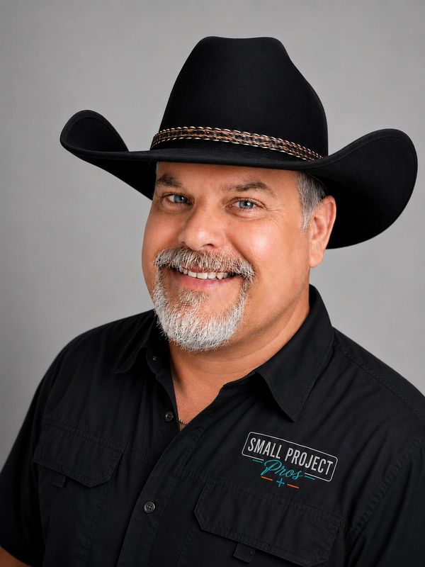 Smiling man wearing a black cowboy hat and a black shirt.