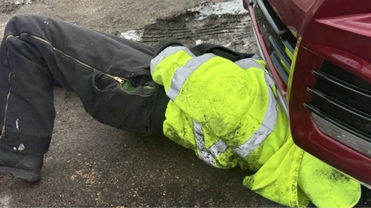 Roadside technician performing on-site vehicle repair during emergency roadside service