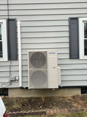 Samsung air conditioning unit installed on house exterior.
