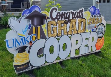 Graduation yard props display in Kansas City for 2026 graduate with bold letters and themed icons