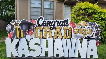 Large graduation yard sign in Kansas City neighborhood featuring custom name and school colors